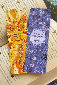 two colorful bookmarks sitting on top of an open book with stars in the background