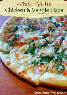 a white garlic chicken and veggie pizza on a wooden table with text overlay