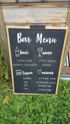 a chalkboard menu sign sitting in the grass