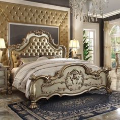 a fancy bedroom with gold furniture and chandelier