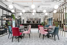 the interior of a restaurant with colorful chairs and tables