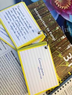 several books are stacked on top of each other with yellow paper attached to the covers