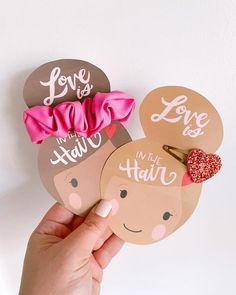 someone holding up some cute hair clips with the words love is in the hair on them