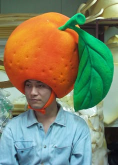 a man wearing an orange hat with a green leaf on it's head,