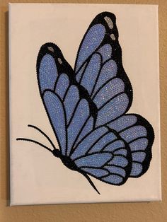 a painting of a blue butterfly on a white canvas with black outline and glitters