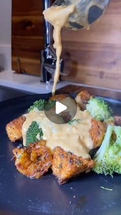 someone is pouring sauce on some chicken with broccoli