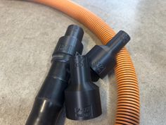 three black and orange hoses laying on the floor