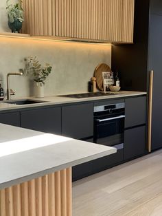 a modern kitchen with black cabinets and white counter tops, along with an island in the middle