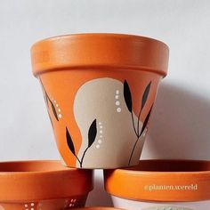 three orange flower pots sitting on top of each other