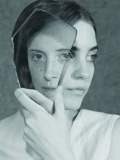 a black and white photo of a woman holding her hand to her face