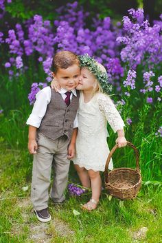 two children are kissing in front of purple flowers and the caption reads, instagram