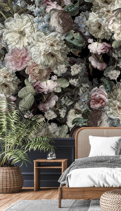 a bed sitting next to a plant in a bedroom under a large wallpapered mural