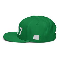 a green hat with white numbers on the front and back side, sitting on a white surface