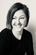 a black and white photo of a woman with short hair smiling at the camera,