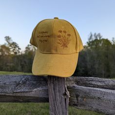 This wood burned yellow faux suede baseball cap would make a great addition to any nature lover's wardrobe. Using a woodburner and my own originial design I hand burnt dandelions on the right side of the crown of the hat. On the left side of the crown I burnt the quote "Wildflowers don't care where they grow". Materials: 100% cotton Hat fits most with an adjustable buckle in the back *Disclaimer* colors may vary slightly from screen to screen Fedora Burning, Dandelion Hat, Hat Cottagecore, Nature Birthday, Hat Burning, Hat Bar, Cottagecore Gifts, Unique Graduation Gifts, Hat Fits