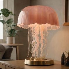 a jellyfish lamp on a table in a room with a couch and potted plant