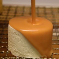 a cake with a candle sticking out of it's center on a cooling rack