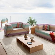 a living room filled with furniture next to the ocean