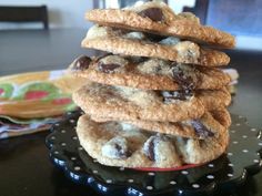 a stack of chocolate chip cookies sitting on top of a black and white polka dot plate