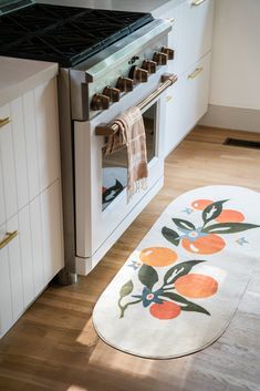 a kitchen with an oven and rug on the floor