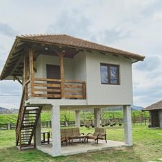 a small house sitting on top of a lush green field