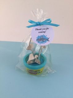 there is a small bowl with two spoons in it and a thank you for reward tag