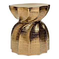 a gold colored stool with an intricate design on it