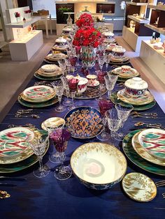 the table is set with many plates and bowls