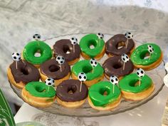 there are many donuts with green frosting and soccer decorations on the top one