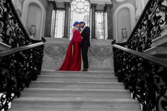 a man and woman are standing on the stairs with their arms around each other as they kiss