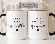 two black and white coffee mugs with the words, let's have together