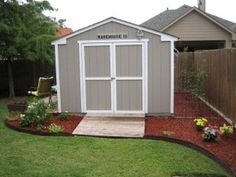 a small backyard with a shed and flower bed