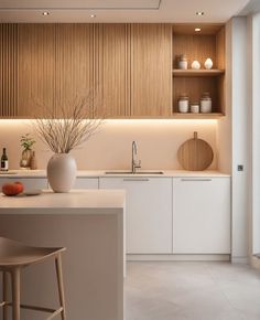 a white kitchen with wooden cabinets and counter tops, along with two bar stools