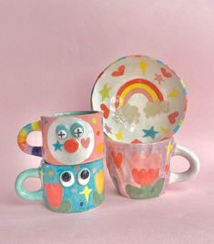 two mugs with faces painted on them and one has a plate in the shape of an owl