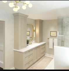 a large bathroom with white cabinets and gold accents