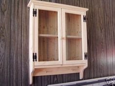 a wooden cabinet sitting on top of a wall