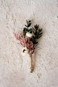 a bouquet of flowers is laying on the floor in front of a white carpeted wall