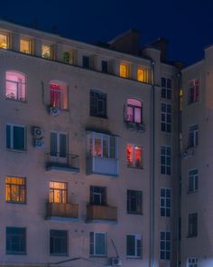 an apartment building with many windows lit up at night