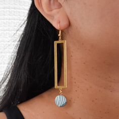 Catch some beach vibes with our Sandy Beaches Earrings! These blue and gold beauties feature a fun ocean print and a long rectangle charm. Perfect for adding a touch of seaside charm to any outfit. Due to the handmade nature of this product, no two earrings are exactly the same. Product Details 3.5" long x 0.75" wide Gold plated french hooks, nickel free Raw brass charm Gold plated pendant tray Glass cabochon Cotton fabric Care Instructions Keep earrings dry, remove when cleaning or near water. Clean with a soft cloth. Store in a dry, enclosed container. Bohemian Rectangular Jewelry For Everyday, Gold Rectangular Jewelry For Summer, Rectangular Gold Summer Jewelry, Rectangular Gold Jewelry For Summer, Minimalist Earrings For Beach And Summer, Rectangular Summer Earrings As Gift, Minimalist Handmade Earrings For Beach, Blue Rectangular Earrings, Blue Rectangular Earrings With Ear Wire