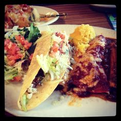 two tacos, one with meat and the other with salad on a white plate