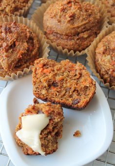 carrot muffins with icing on a plate next to other muffins