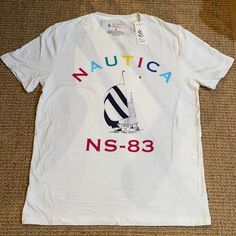 Nautica T-Shirt. Limited Edition Spinnaker Design. Soft Cotton. Rainbow Letters. Versatile And Fun. Thanks For Shopping! Nautical Cotton T-shirt With Graphic Print, Nautical Cotton T-shirt With Short Sleeves, Nautical Style Cotton T-shirt With Short Sleeves, White Nautical Short Sleeve T-shirt, White Nautical Style Short Sleeve T-shirt, White Short Sleeve Nautical T-shirt, White Nautical Short Sleeve Tops, Nautical Style Cotton T-shirt With Graphic Print, White Nautical Crew Neck Top