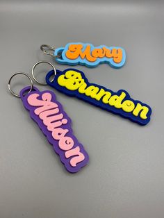 three different colored key chains with the words new york and san francisco on them, sitting next to each other