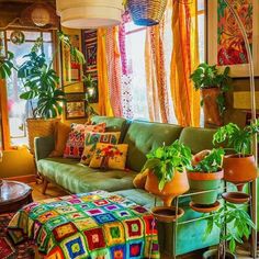 a living room filled with lots of plants next to a couch and coffee table in front of a window