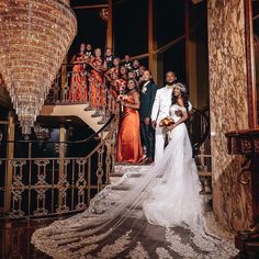 a bride and groom standing on the stairs with their bridal party