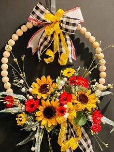 a wreath with sunflowers and other flowers hanging on a door