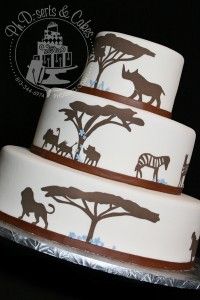 three tiered cake decorated with animals and trees on it's side, in front of a black background