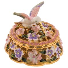 a decorative box with flowers and a bird on it's lid, sitting in front of a white background