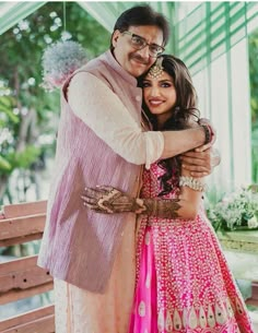 a man and woman hugging each other in front of a building