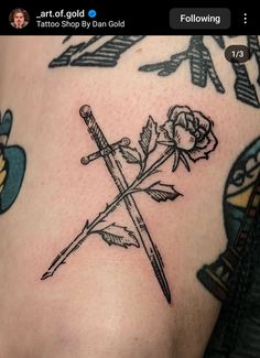 a tattoo with two crossed swords and a rose on it